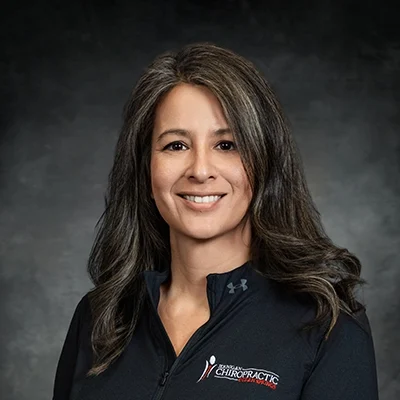 Saira Zimmerman Smiling In Front Of Grey Background